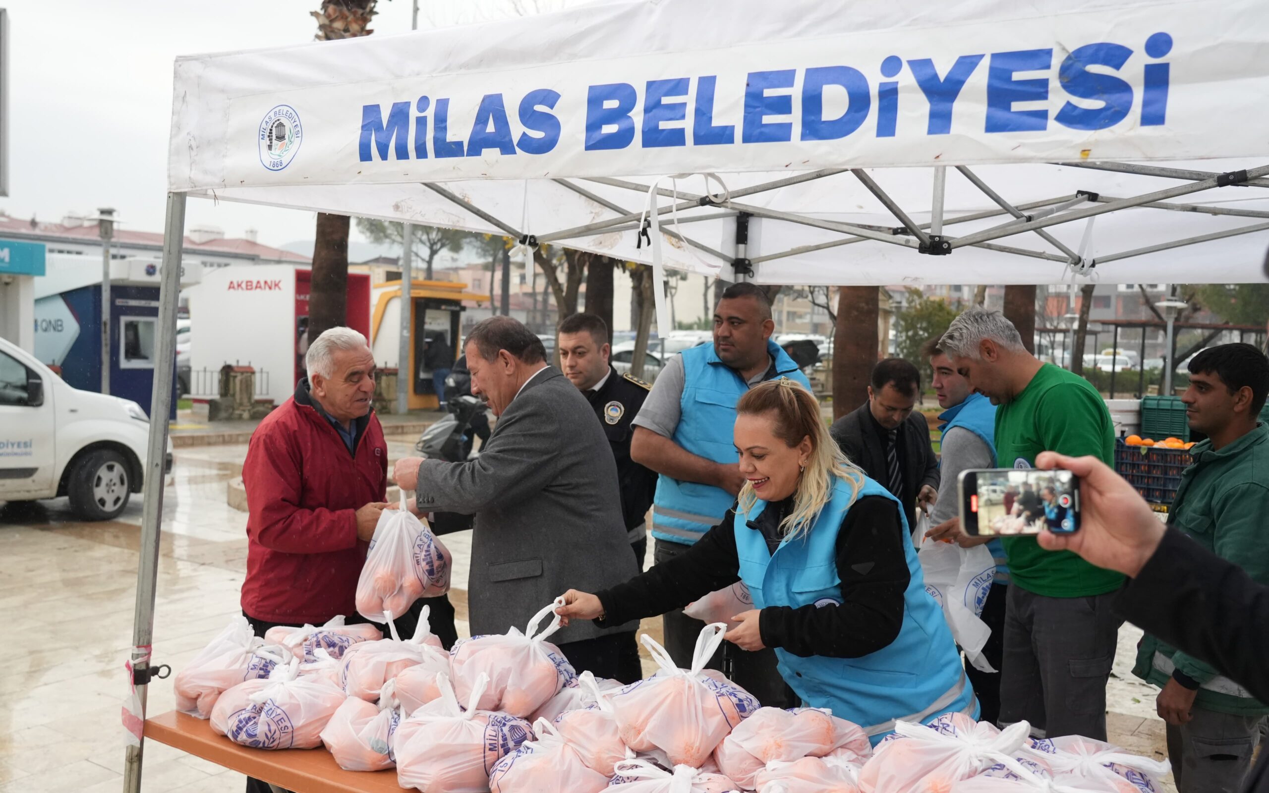 MİLAS BELEDİYESİ HEM ÜRETİCİYE HEM DE TÜKETİCİYE DESTEK OLDU
Milas Belediyesi üreticilere destek olmak ve vatandaşların sağlıklı gıda ihtiyacını karşılamak amacıyla ücretsiz olarak dağıtmak üzere portakal satın aldı.
Ürünleri elinde kalan portakal üreticisinin imdadına Milas Belediyesi yetişti. Zor durumda kalan üreticiye destek olmak ve vatandaşın C vitamini ihtiyacını karşılamak için üreticinin elinde kalan yaklaşık 3 ton portakalı değerinde alan Milas Belediyesi ürünleri poşetleyerek Atapark Meydanı’nda vatandaşlara ücretsiz olarak dağıtımını gerçekleştirdi.
Atapark Meydanı’nda bulunan vatandaşlara elleriyle ürünleri dağıtan Milas Belediye Başkanı Fevzi Topuz, üreticilerin her zaman yanında olduklarını belirterek hizmetlerin artarak devam edeceğini ifade etti. Önemli bir projenin hayata geçtiğini belirten vatandaşlar ise Milas Belediyesi’ne teşekkür etti. 
Vatandaşlarımızın sağlığı ve üreticimizin yüzünün gülmesi için önemli bir çalışma gerçekleştirdik…
Sosyal belediyecilik adına önemli çalışmalar gerçekleştirdiklerini belirten Milas Belediye Başkanı Fevzi Topuz, Yetiştirdiği ürünleri elinde kalan üreticilerimizden değerinde satın aldığımız portakalların vatandaşlarımızın sağlıklı gıdaya erişmesi ve C vitamini ihtiyacını karşılamak için ücretsiz olarak dağıtımını gerçekleştirdik. Soğuk kış günlerinde hem vatandaşlarımızın sağlığı hem de üreticimizin yüzünün gülmesi için önemli bir çalışma gerçekleştirmiş olduk. Vatandaşlarımızın hizmetimizden duyduğu memnuniyet bizleri oldukça mutlu etti. Milas Belediyesi olarak vatandaşlarımızın yanında olmaya bundan sonraki süreçte de devam edeceğiz” dedi. 

